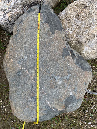 A tape measure spread the length of a boulder