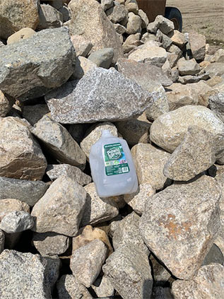 A water jug in a pile of small boulders to illustrate boulder size